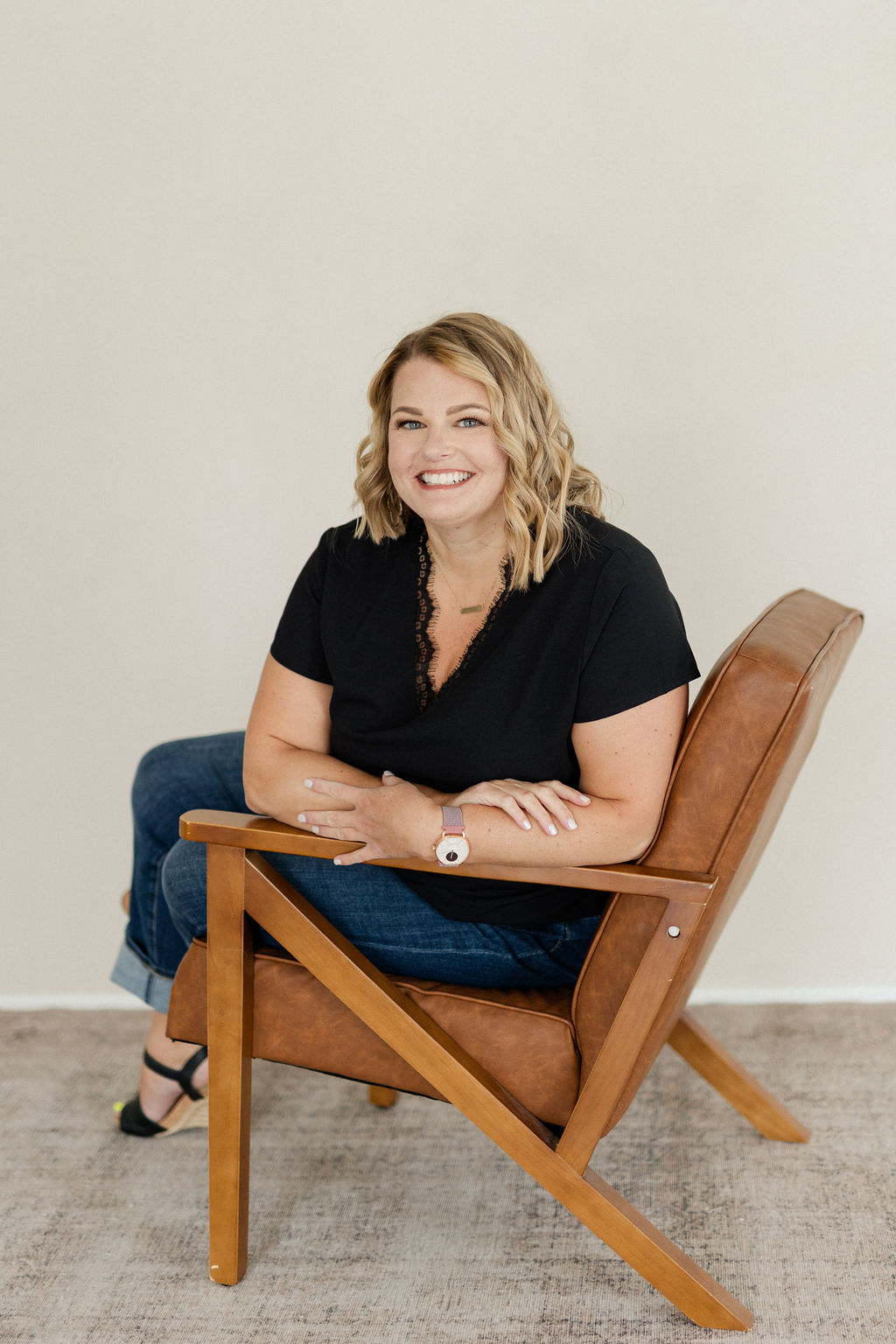Photo of Lynn Marie Debilzen, founder of The Collective Shift Co., smiling and looking into the distance, with a laptop. 