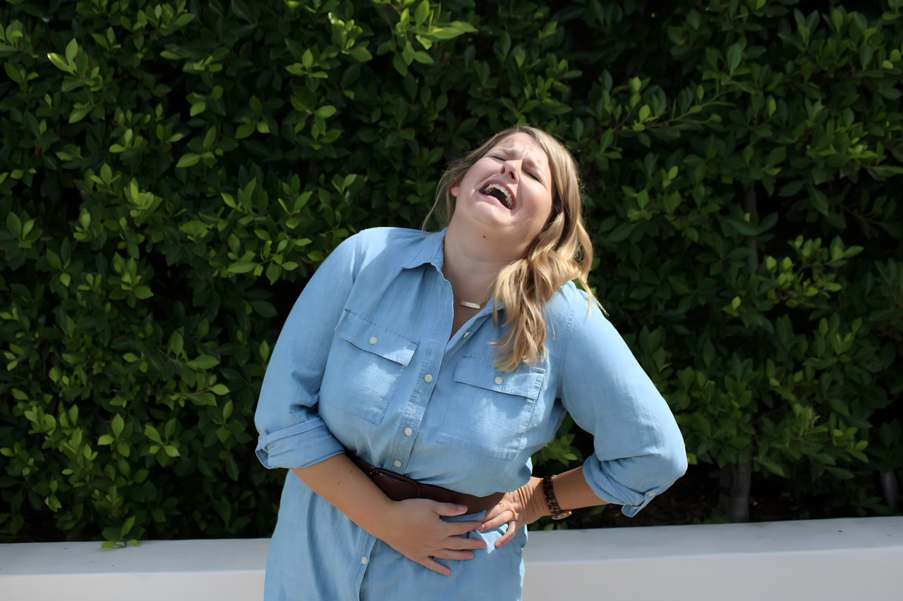 Photo of Lynn Marie Debilzen, founder of The Collective Shift Co., laughing with her head thrown back and a side stitch